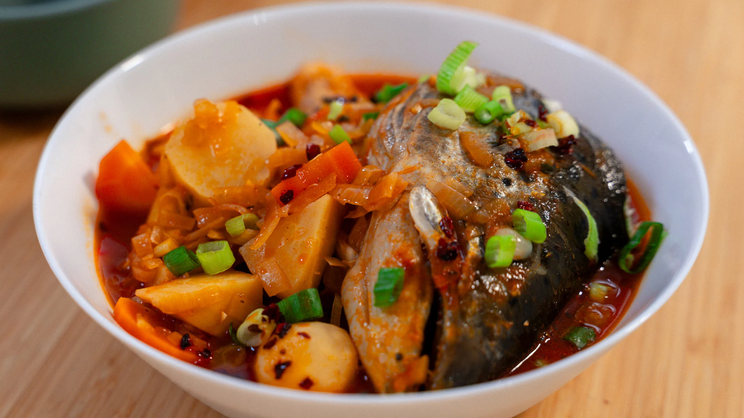Fish head soup with noodles and vegetables.