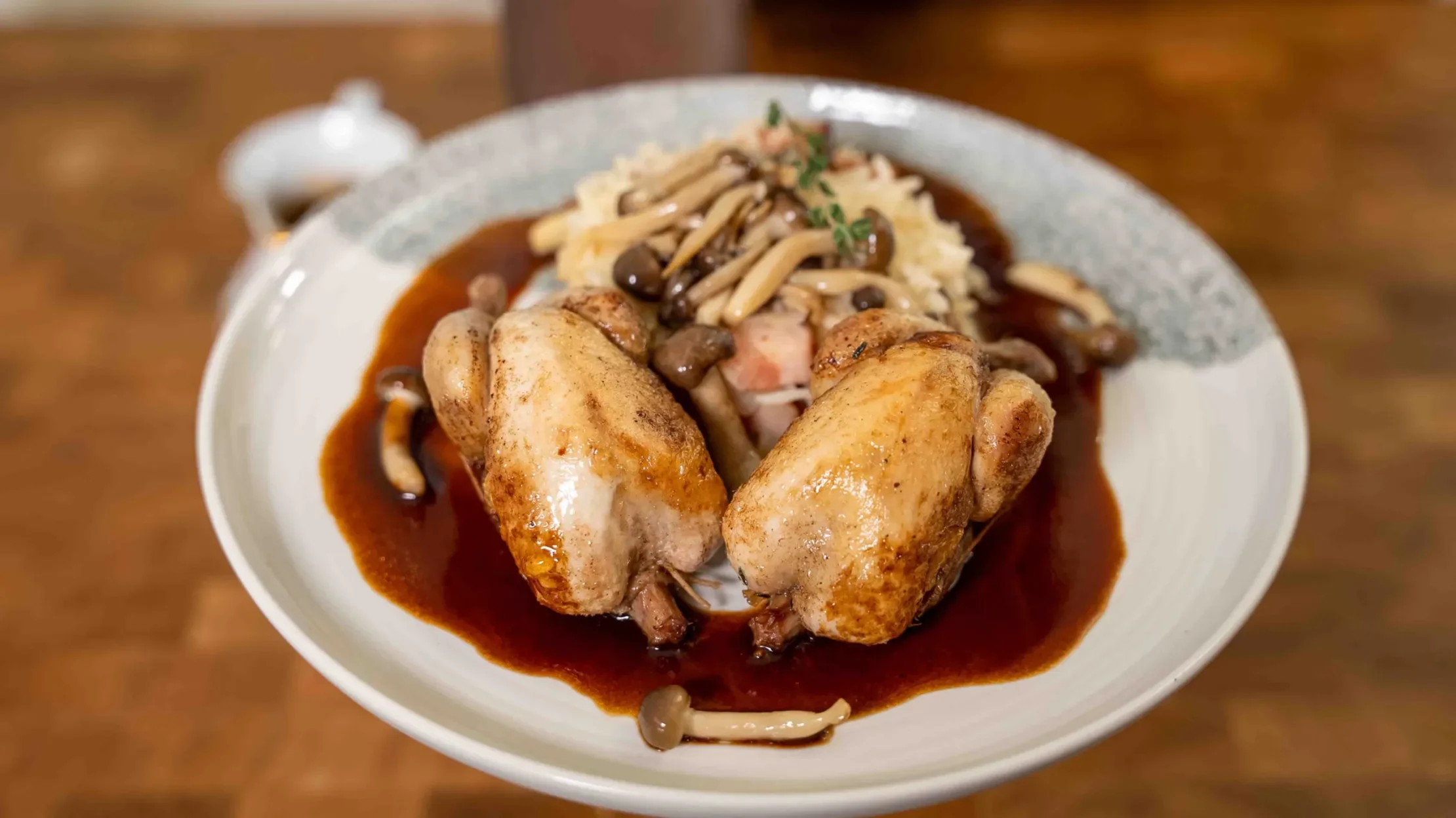 Quail with rice, red wine sauce, and mushrooms.